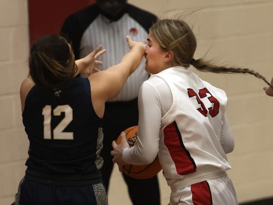 Lady Owl Kelby Carter (33) gets smacked in the nose by a Kingfisher defender during last Friday’s game as she attempts a move toward the basket. HUGH SCOTT JR. | SOUTHWEST CHRONICLE