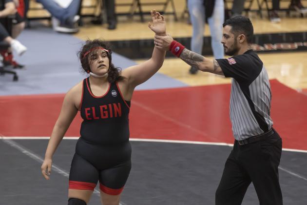 Symphony Veloz raises her hand after being declared the winner by the match referee. Veloz pinned her opponent in the third period. HUGH SCOTT JR. | SOUTHWEST CHRONICLE