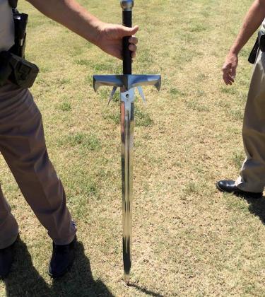 Brandishing this sword, Robert Sturgis Powers is accused of threatening a Hilliary Communications employee and stabbing the front tires of a company bucket truck.  