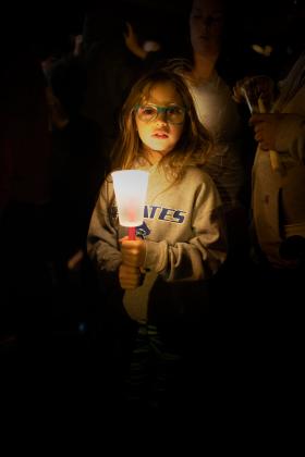 Harper Cooper, 9, of Cyril, attends a candlelight vigil for 4-year-old Athena Brownfield Saturday night in Cyril. STEVE BOOKER | SOUTHWEST CHRONICLE