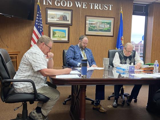 From the left, Comanche County Commissioners John O’Brien, Josh Powers and Johnny Owens sign papers during Monday’s meeting. The commission finalized American Rescue Plan Act grants for the town of Indiahoma and the Comanche County Fairgrounds Trust Authority. ERIC SWANSON | SOUTHWEST CHRONICLE