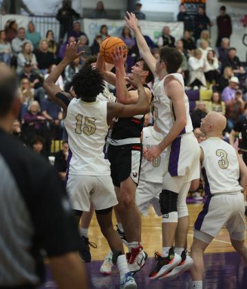 Elgin's Christian Reed tries to shoot the ball while surrounded by Community Christian defenders Friday night. Reed finished with 12 points as the Owls won their sixth district championship in seven years. (Photo by Hugh Scott Jr.)