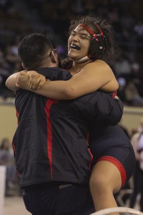 Elgin’s Symphony Veloz jumps into the arms of her dad and assistant coach, Robert Veloz, after winning the 170-pound state title match last Saturday. This was Robert Veloz’ first time to witness his daughter’s performance at a state meet. In the two previous years, he was serving overseas in the U.S. military when Symphony Veloz competed. Last year, his daughter won the state title at 165 pounds. HUGH SCOTT JR | SOUTHWEST CHRONICLE