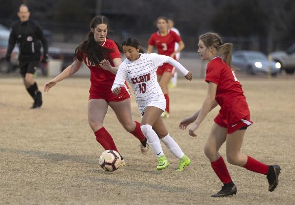 Elgin’s Annelis Perez dribbles through two McLoud defenders on her way to the McLoud goal. Perez scored her second goal of the season Tuesday night. HUGH SCOTT JR. | SOUTHWEST CHRONICLE