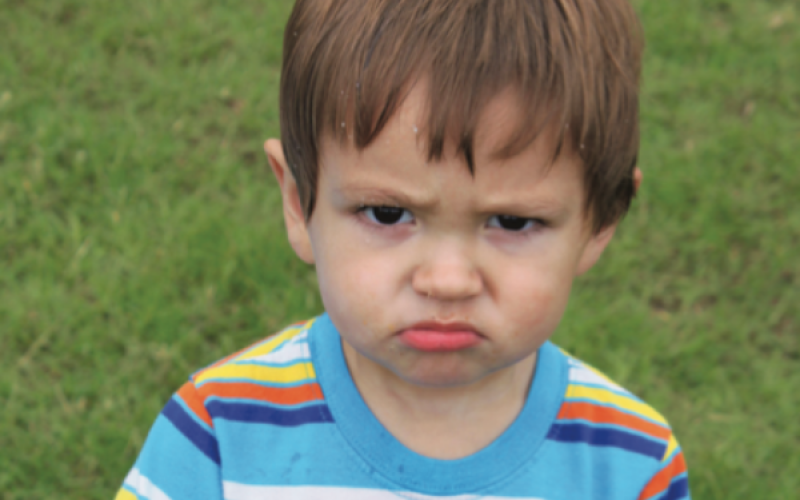 A disgruntled toddler shows his disappointment with his malfunctioning bubble gun