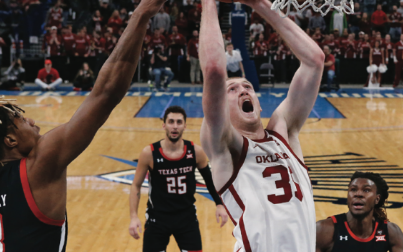 Oklahoma forward Brady Manek shoots between Jahmi’us Ramsey and guard Chris Clarke in a basketball game in Oklahoma City.