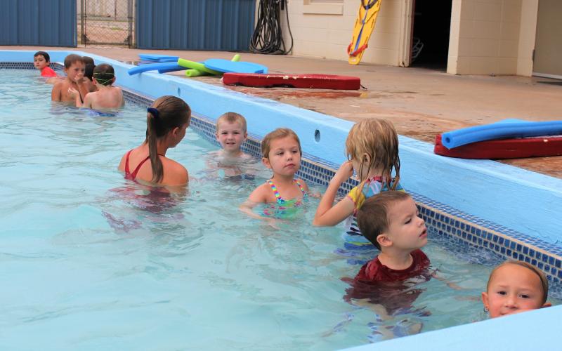 Lifeguard Rachel Gregg works with a group of beginning swimmers in the shallow end of the pool.