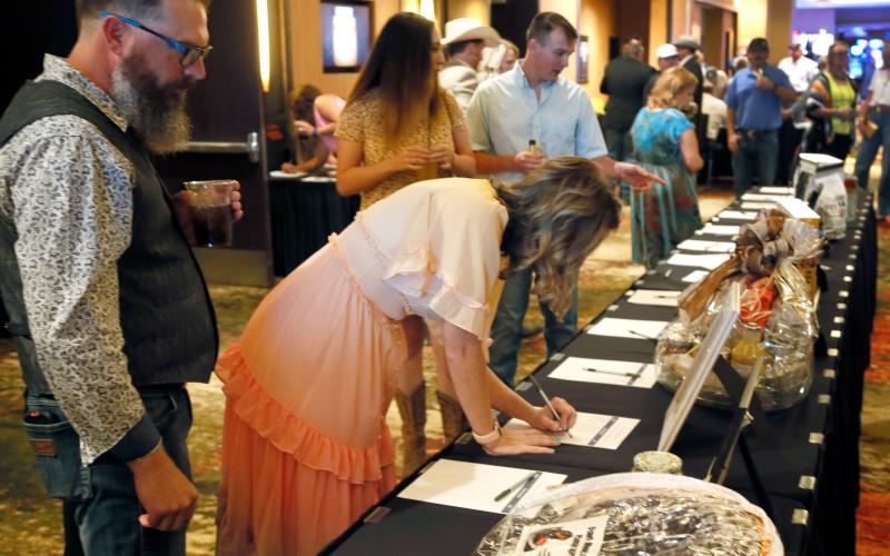 Dr. Holly Lunsford and her husband Brian sign up for a silent auction item at the Saddle &amp; Sirloin Club's dinner and live auction on July 16th in Lawton Rip Still/Ledger