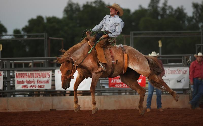 Garrett Tucker, of Elgin, competes in the first round of bronc riding at the Chickasha Open Rodeo held June 24-25 at the Grady County Fairgrounds. Tucker finished third in the competition.  (Photo by Hugh Scott)