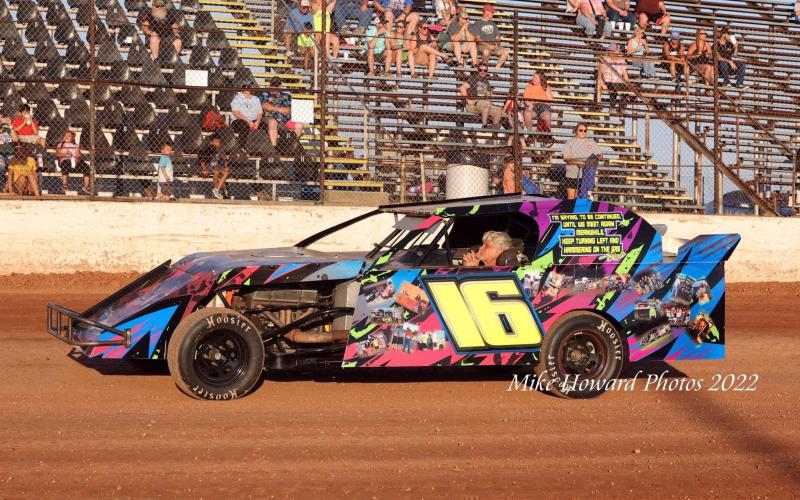 WAITING: Jim Bland sits in the seat of the No. 16 car as the fans rise in the background in anticipation of the national anthem before the start of the Rob Bland Memorial Race.  Photo by Mike Howard Photography