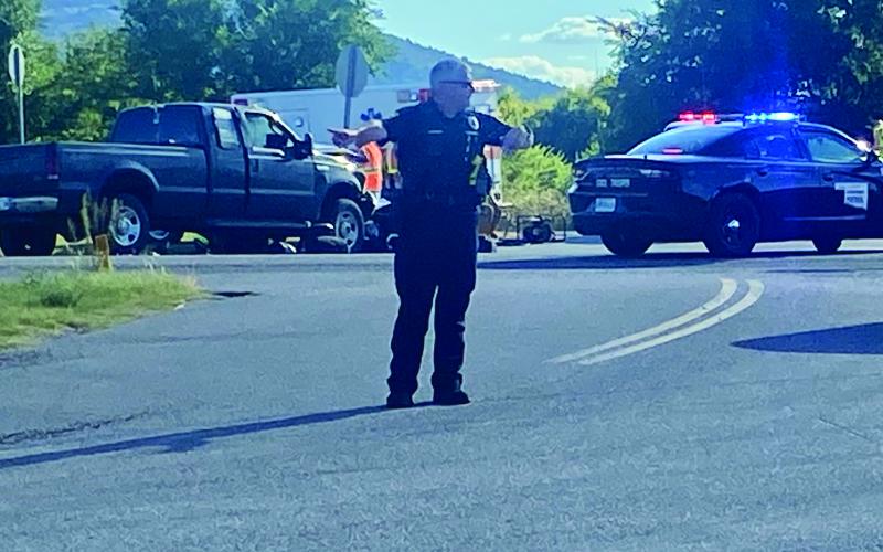 A Lawton police officer directs traffic Tuesday at the intersection of NW Miller Road and NW Porter Hill Road, near the scene of a fatal accident at state Highway 58 and Porter Hill Road. Eric Swanson /Staff photo