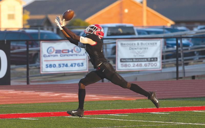 Elgin’s junior wide receiver Michael Adesola (4) reaches to catch a ball thrown by quarterback Tres Lorah….  ….and tucks the ball away at the El Reno 2-yard line….  ….then dives at the orange pylon….  ….before placing the ball over the goal line for a 38-yard TD pass play. (Photos by Hugh Scott Jr.)