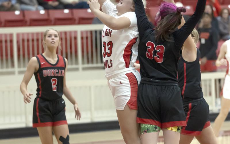 Elgin freshman Kelby Carter (33) toss the ball toward the basket while guarded by Duncan defenders during a recent game. HUGH SCOTT JR. | SOUTHWEST CHRONICLE