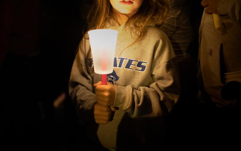Harper Cooper, 9, of Cyril, attends a candlelight vigil for 4-year-old Athena Brownfield Saturday night in Cyril. STEVE BOOKER |  SOUTHWEST CHRONICLE