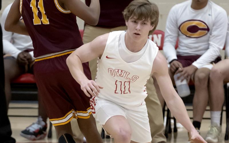 Elgin’s Denton Glover (11) dribbles past a Clinton defender during the Owls’ 56-25 win on Tuesday. HUGH SCOTT JR. | SOUTHWEST CHRONICLE