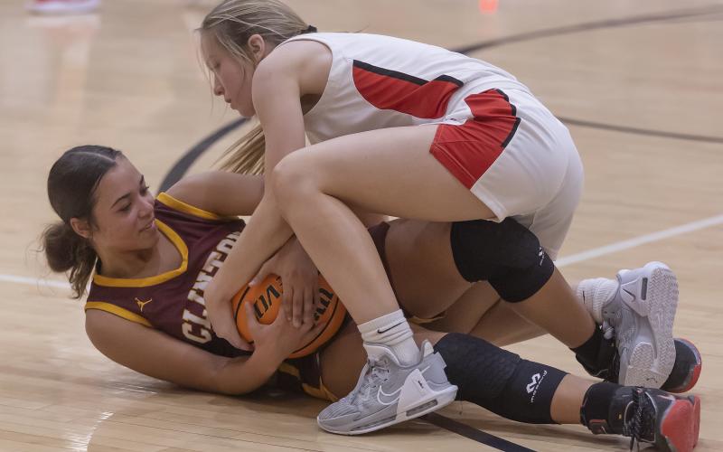 Elgin’s Kenley York (top) battles for the ball against a Clinton player Tuesday night during the Lady Owls’ 60-30 win. HUGH SCOTT JR. | SOUTHWEST CHRONICLE