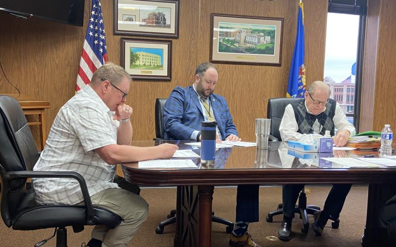 From the left, Comanche County Commissioners John O’Brien, Josh Powers and Johnny Owens sign papers during Monday’s meeting. The commission finalized American Rescue Plan Act grants for the town of Indiahoma and the Comanche County Fairgrounds Trust Authority. ERIC SWANSON | SOUTHWEST CHRONICLE