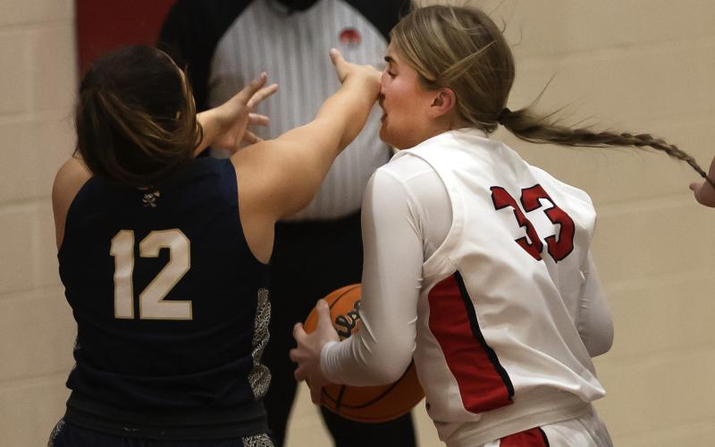Lady Owl Kelby Carter (33) gets smacked in the nose by a Kingfisher defender during last Friday’s game as she attempts a move toward the basket. HUGH SCOTT JR. | SOUTHWEST CHRONICLE
