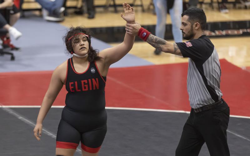 Symphony Veloz raises her hand after being declared the winner by the match referee. Veloz pinned her opponent in the third period. HUGH SCOTT JR. | SOUTHWEST CHRONICLE