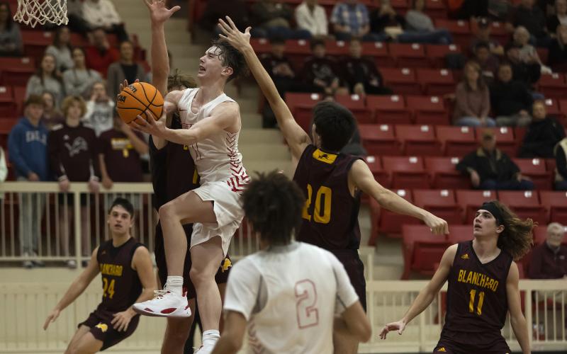 Elgin’s Jake Lohman drives down the lane as a pair of Blanchard defenders try to block the shot during the Feb. 6 make-up game. Elgin hosts Kingfisher Friday and then travels to Weatherford Saturday. HUGH SCOTT JR. | SOUTHWEST CHRONICLE