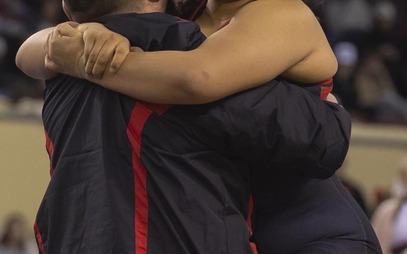 Elgin’s Symphony Veloz jumps into the arms of her dad and assistant coach, Robert Veloz, after winning the 170-pound state title match last Saturday. This was Robert Veloz’ first time to witness his daughter’s performance at a state meet. In the two previous years, he was serving overseas in the U.S. military when Symphony Veloz competed. Last year, his daughter won the state title at 165 pounds. HUGH SCOTT JR | SOUTHWEST CHRONICLE