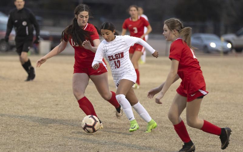 Elgin’s Annelis Perez dribbles through two McLoud defenders on her way to the McLoud goal. Perez scored her second goal of the season Tuesday night. HUGH SCOTT JR. | SOUTHWEST CHRONICLE