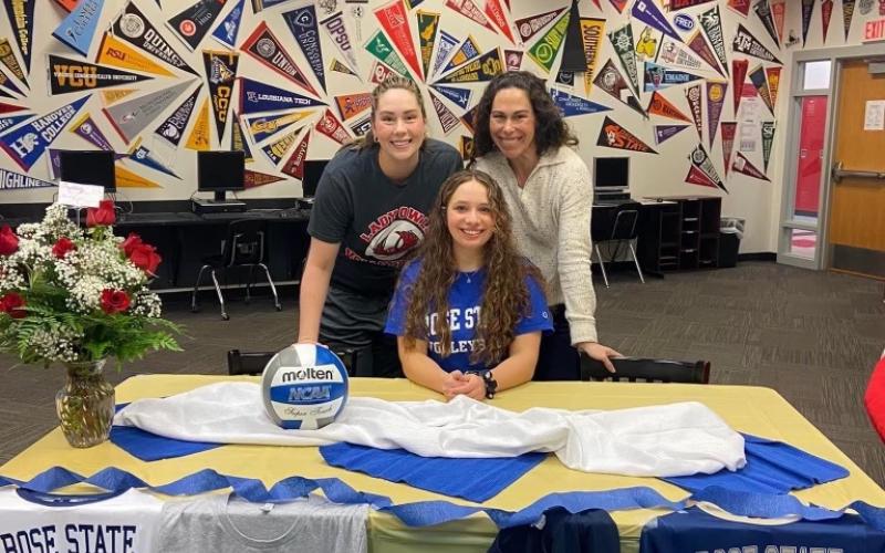 Sarah Schuh, seated, signs a ceremonial letter of intent to play volleyball at Rose State College in the fall. Schuh is expected to be a defensive specialist at Rose State. PHOTO PROVIDED