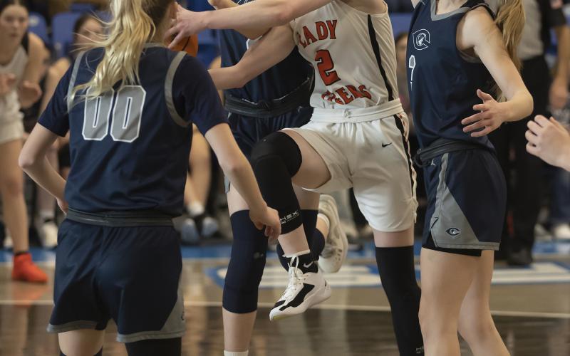 Senior Emma Nunley drives to the basket through two defenders during recent playoff action. Nunley tallied eight points in her final game as a Lady Tiger, when Sterling lost to Okeene last week in the Area Tournament. HUGH SCOTT JR. | SOUTHWEST CHRONICLE
