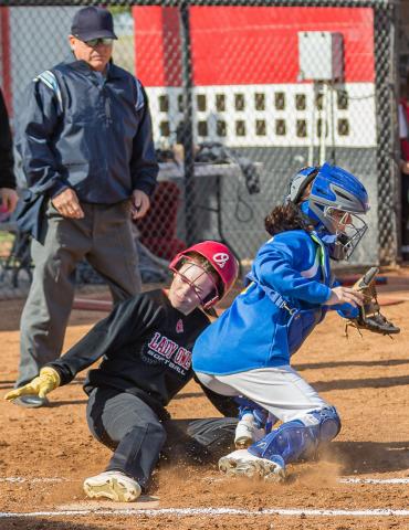 SLIDING HOME: Elgin's base runner slides in at home during the Fletcher tournament on April 15.  Photos by Rick Endicott