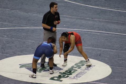 Elgin Lady Owl wrestler Symphony Veloz (red singlet) competes at the 16U National Championship in Fargo, North Dakota, defeating two other wrestlers to become an All-American. Photos by Melody Veloz
