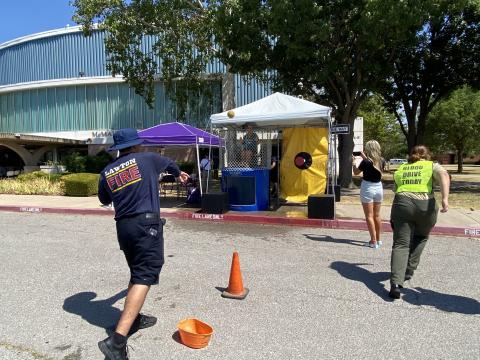Corporal Stiven Jimenez, Lawton Fire Department, throws ball at the dunk tank where Dr. Krista Ratliff, president and CEO of Lawton-Fort Sill Chamber of Commerce, awaits the splash. Photos by Curtis Awbrey