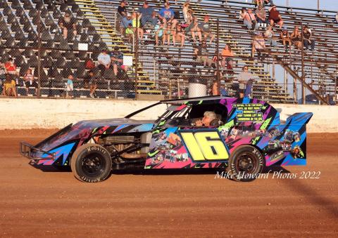WAITING: Jim Bland sits in the seat of the No. 16 car as the fans rise in the background in anticipation of the national anthem before the start of the Rob Bland Memorial Race.  Photo by Mike Howard Photography