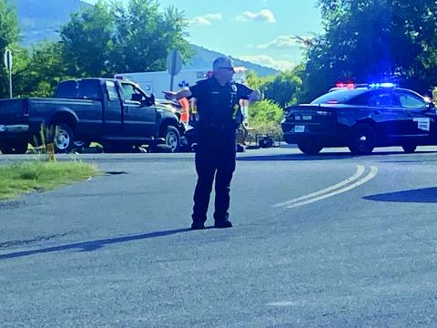 A Lawton police officer directs traffic Tuesday at the intersection of NW Miller Road and NW Porter Hill Road, near the scene of a fatal accident at state Highway 58 and Porter Hill Road. Eric Swanson /Staff photo