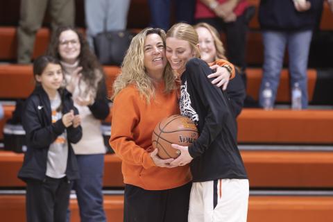 Hugh Scott Jr. | swchronicle Sports Sterling senior Emma Nunley, right, accepts a hug from her coach Jennifer Garner as the home crowd cheers her milestone of scoring 1,000 points during her high school career. Nunley was presented with a professionally stitched ball that reads, “Emma Nunley, 1,000 career points, 2023.” 