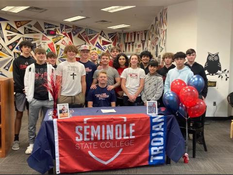 Surrounded by teammates, Elgin baseball player Jake Thomas signs a letter of intent to play for Seminole State College next season. The ceremony was held Wednesday at the Elgin High School library. PHOTO PROVIDED