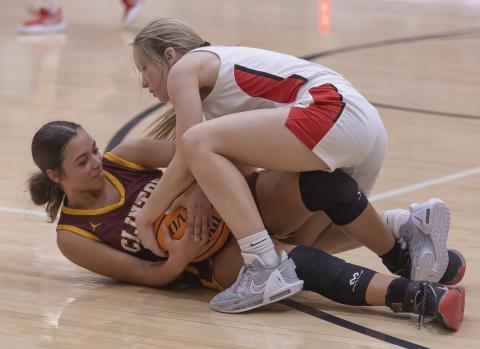 Elgin’s Kenley York (top) battles for the ball against a Clinton player Tuesday night during the Lady Owls’ 60-30 win. HUGH SCOTT JR. | SOUTHWEST CHRONICLE